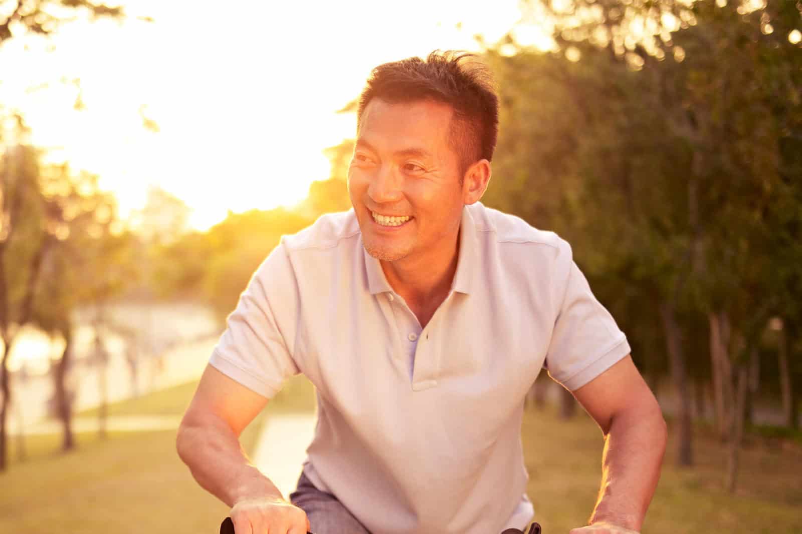 Healthy man riding his bike with sunset