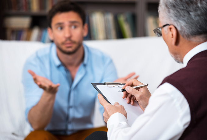 Health professional discussing family violence with a man