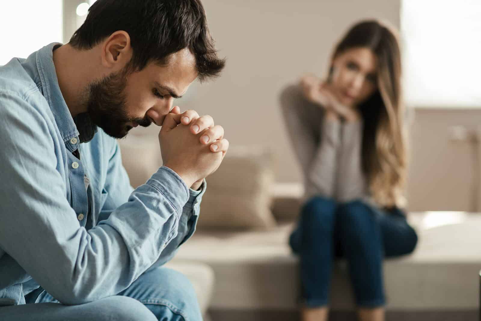 Couple looking concerned sitting at home