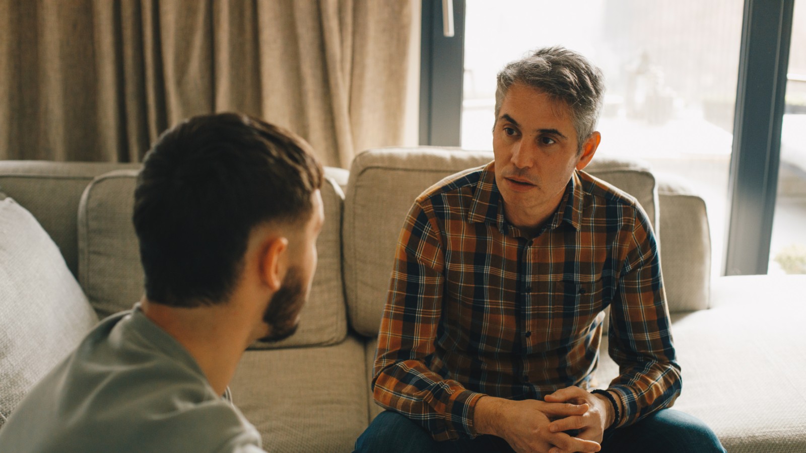 Two men sitting inside having a serious conversation