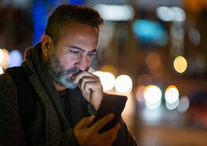 Man looking at phone with serious expression