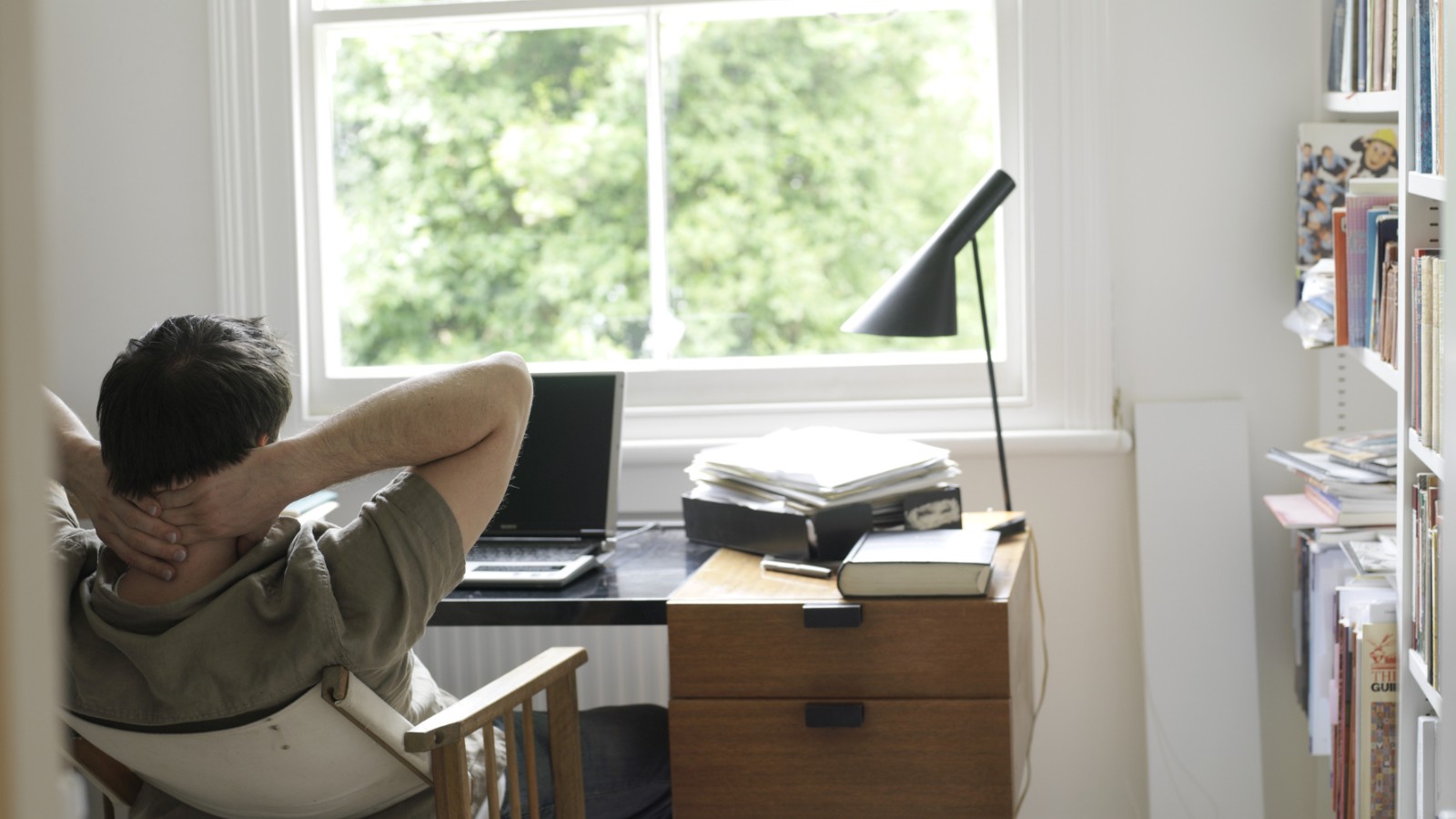 Man sitting at desk in front of laptop looking tense