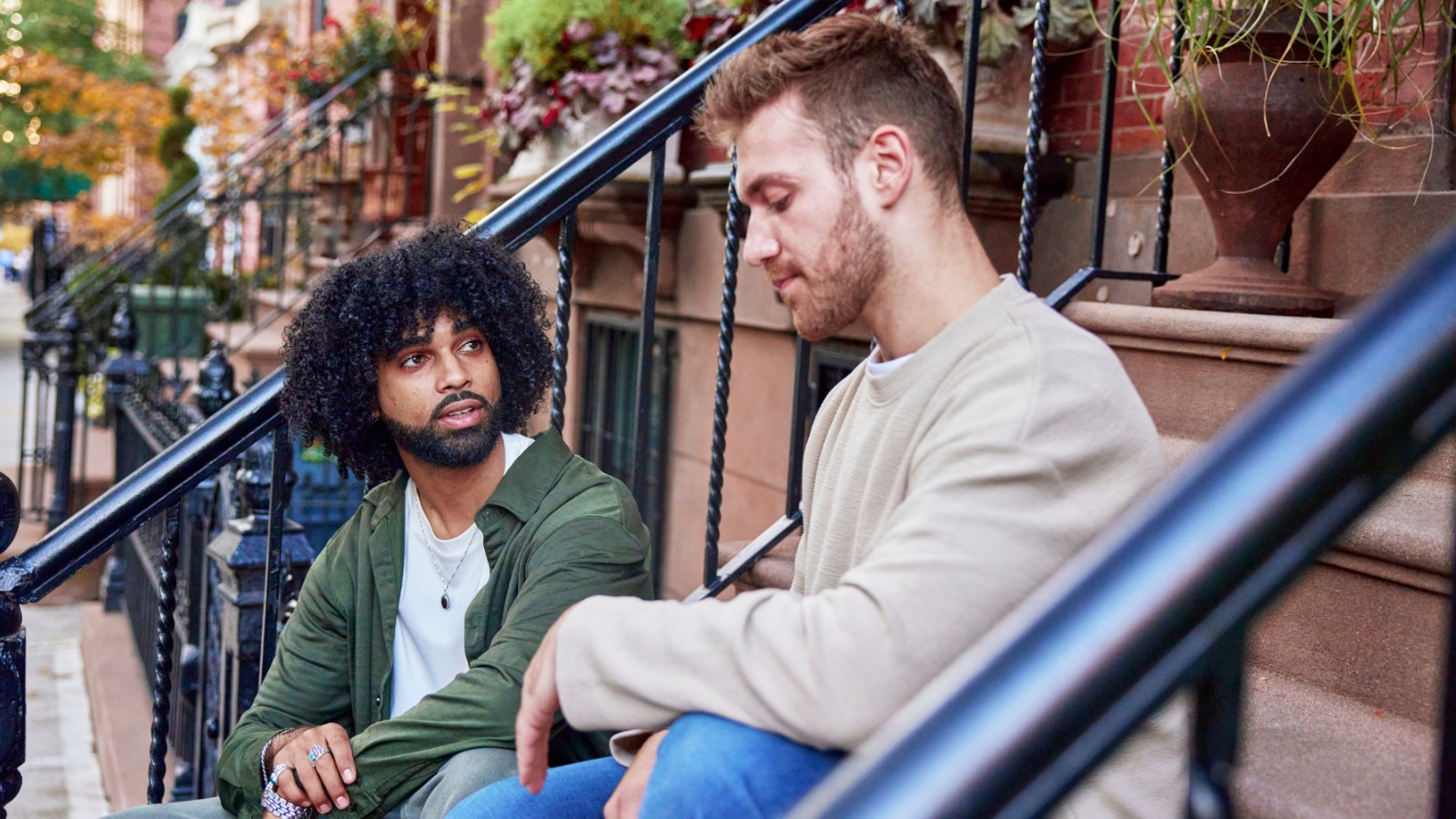 Two males sitting on a step talking