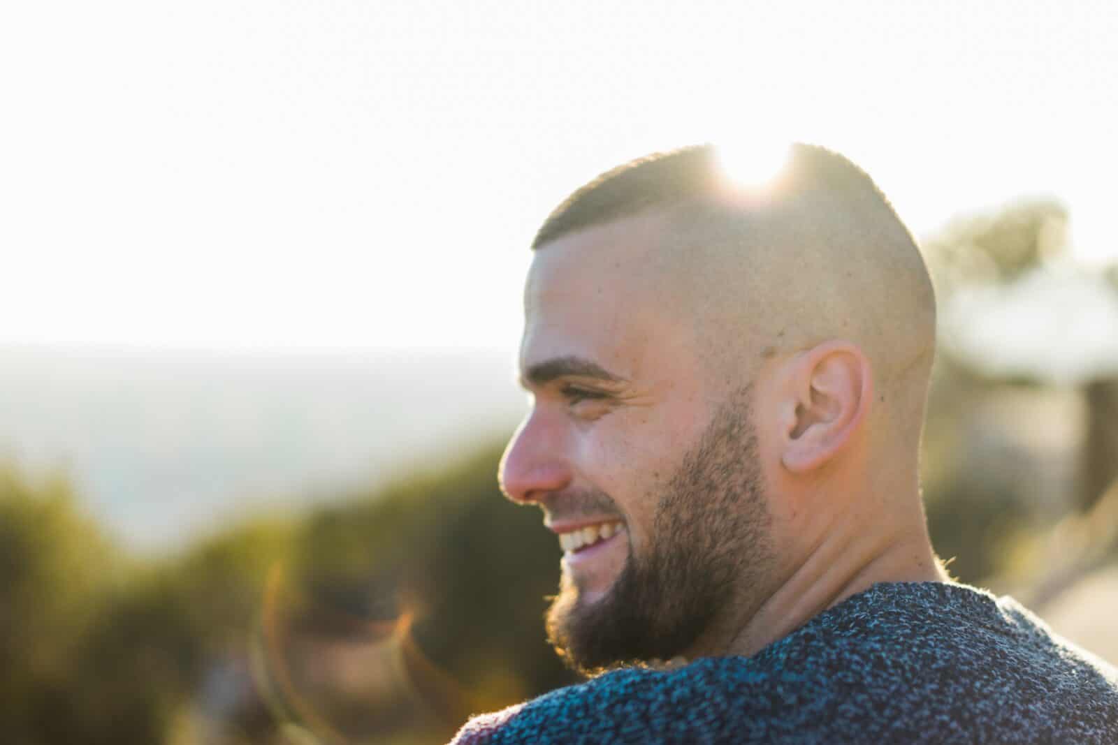 Close up portrait of man outside smiling and looking happy