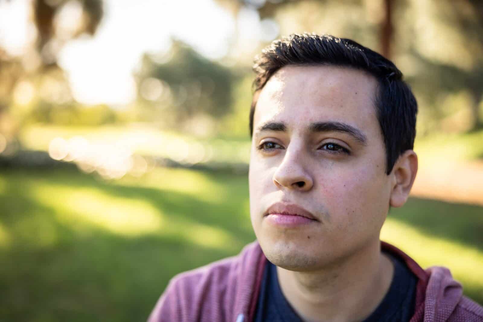 Close up portrait of male standing outside thinking